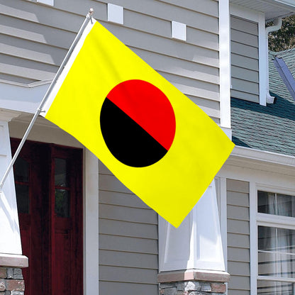 Yellow flag with a red and black circle in the center, mounted on a white house exterior.