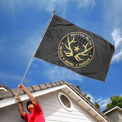 Black Whitetail Militia flag with yellow circular emblem, deer antlers, star, and text, flying outdoors.